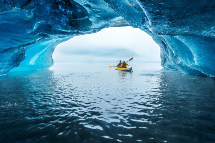Kayakers in a blue ice cave in Alaska.