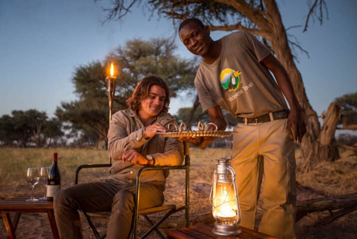 A Botswana private mobile camp staff serving food.