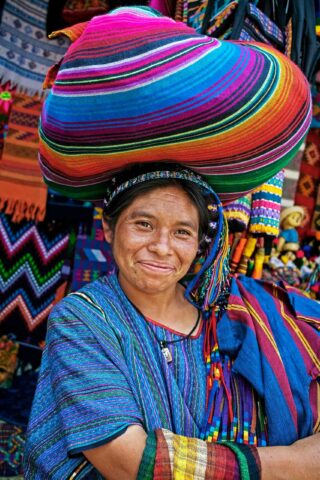 A local woman surrounded by Mayan textiles.
