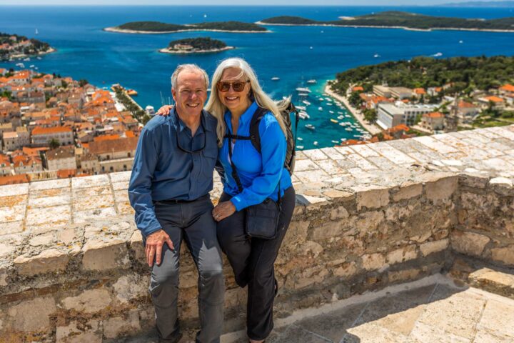 A couple posing with an ocean view in the background in Croatia.