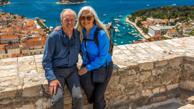 A couple posing near scenic view of ocean in Croatia.