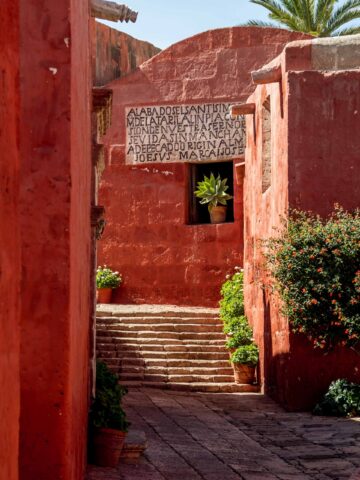 An ancient red wall with inscriptions in Arequipa, Peru.