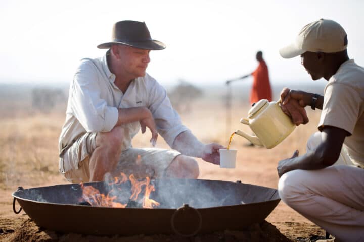 A traveler being served coffee on a safari.