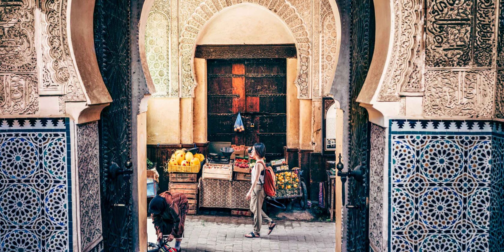 A tourist walking by a market stand.